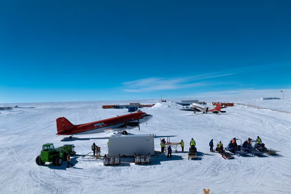 Tarmac at Dome C. Two Basler aircrafts (DC-3) bringing personnel and cargo. The Skidoo crew is ready to unload the cargo